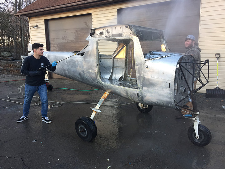 Sophomore Josh Lake and junior Dale McConnell wash and prepare an airplane for paint.
